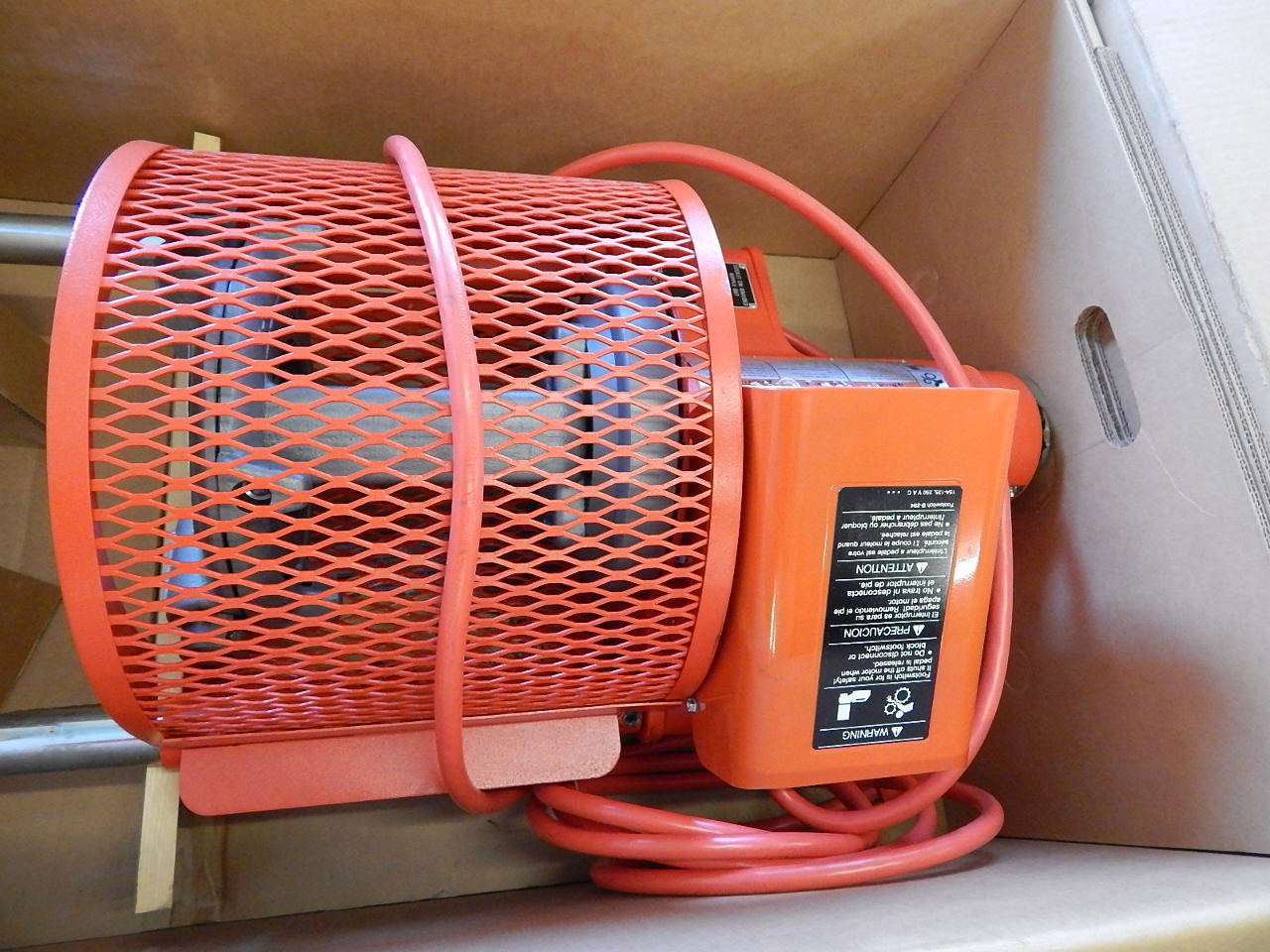 A reconditioned red Aeroquip FT1013-1-5 electric motor with a metal mesh cover and power cord sits in a box, designed for use with a reusable hose assembly machine. The motor features a black label detailing specs and instructions.