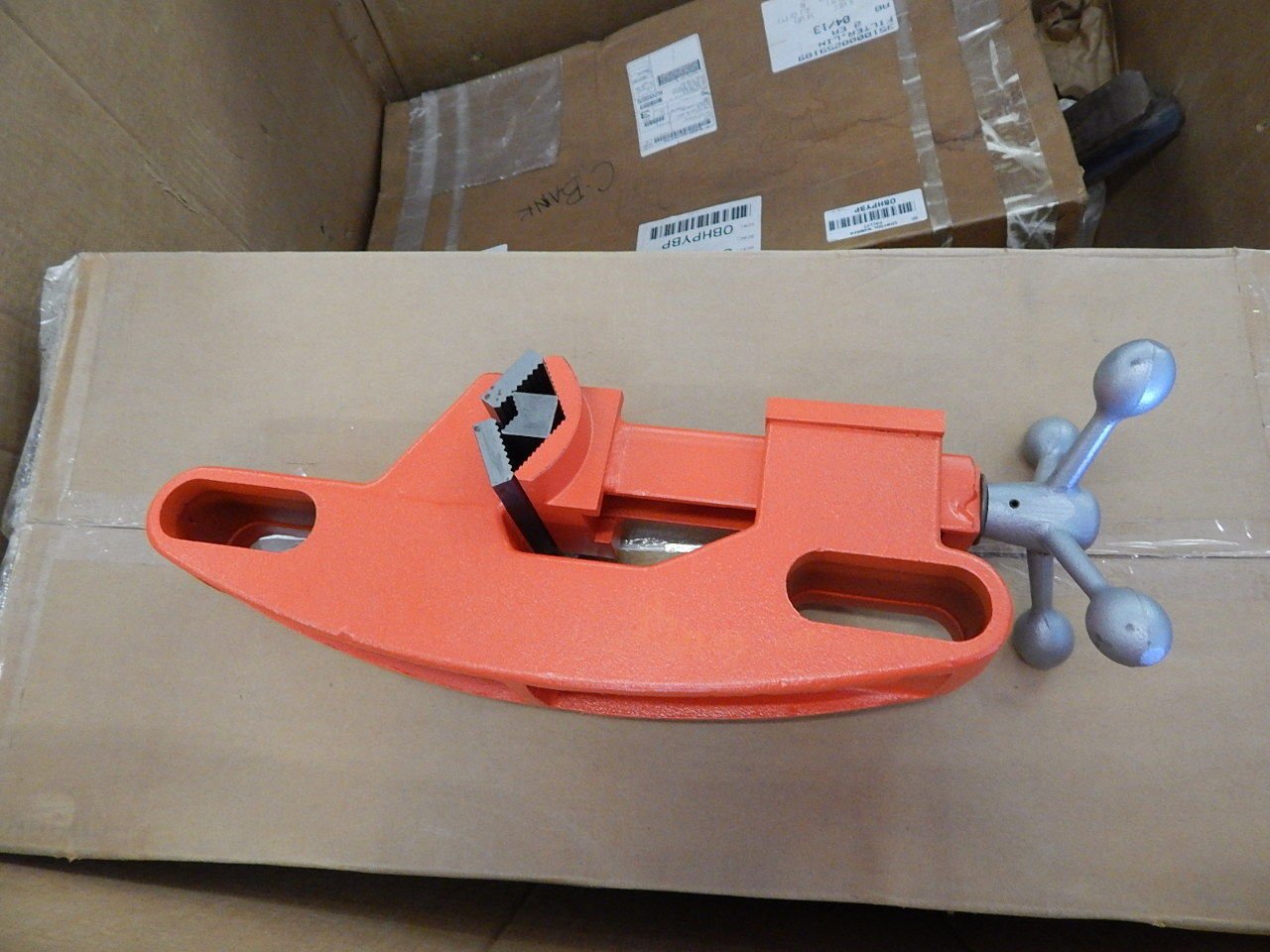 A reconditioned Aeroquip FT1013-1-5 Reusable Hose Assembly Machine with an orange metal body and silver handle rests atop a shipping-labeled box, all placed inside a larger cardboard container.