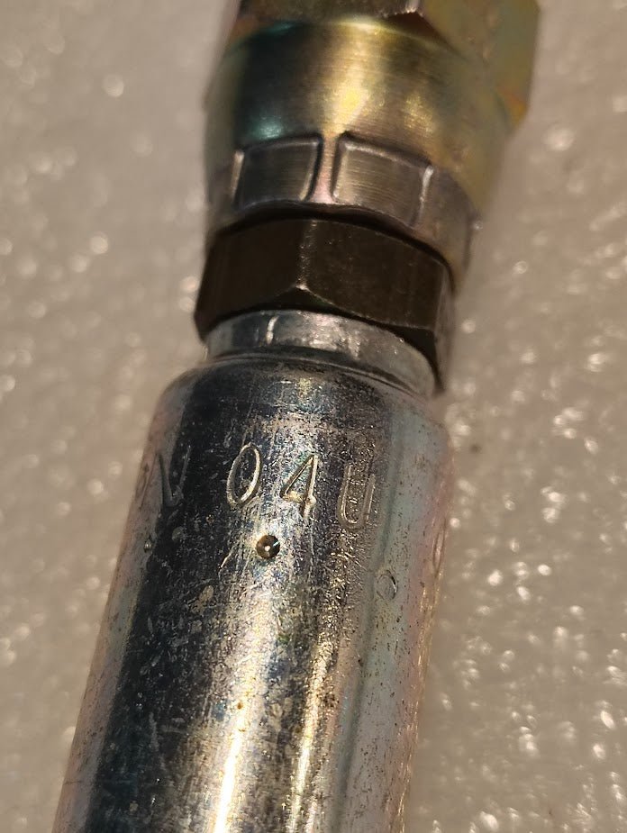 Close-up of a Weatherhead 04U-04L 1/4 Hose x 1/4 JIS Female Fitting (CS40-4X4) with 04U embossed on its side, set against a textured white background.