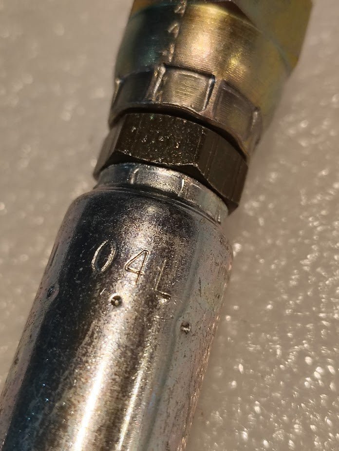 Close-up of a Weatherhead 04U-04L 1/4 Hose x 1/4 JIS Female Fitting (CS40-4X4), showing engraved number 041 on its metallic surface, placed on a textured white background.