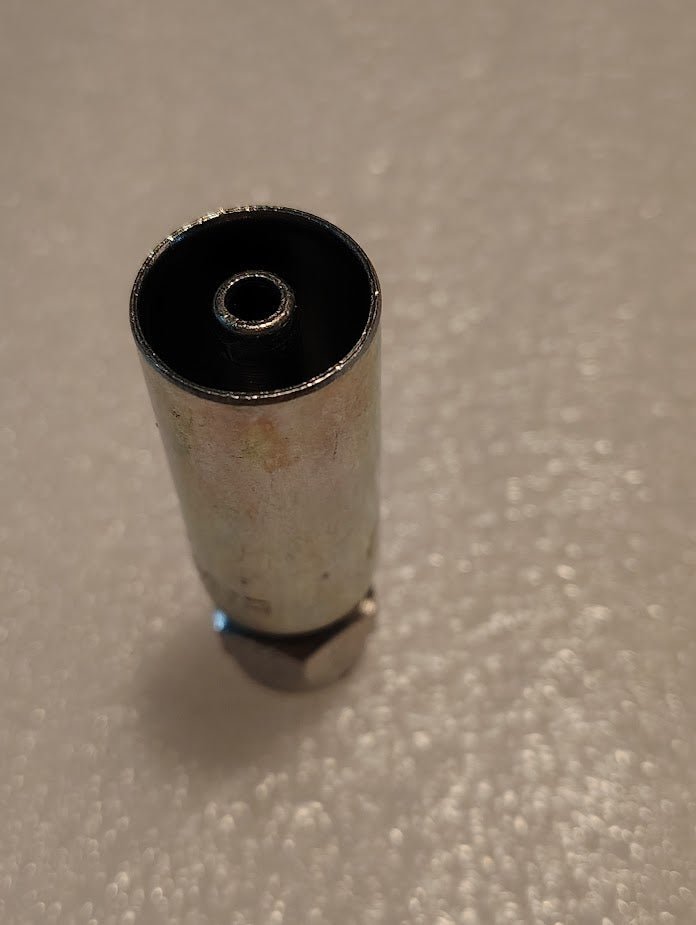 Close-up of a metallic socket wrench on a textured white surface alongside Weatherhead 04U-202 fittings. The open end is upward, revealing a smaller socket inside. The wrenchs exterior and fittings appear slightly worn, suggesting extensive use with hydraulic hose fittings in the past.
