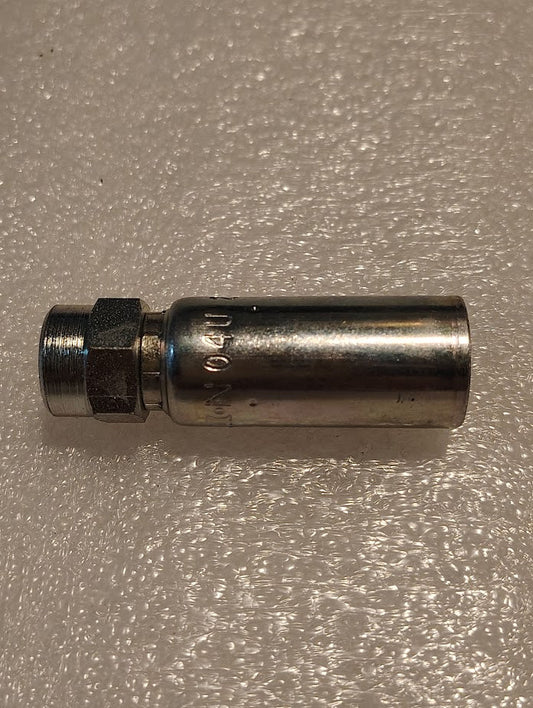 A Weatherhead 04U-202 (1/4 hose x 1/8 NPTF female) metal fitting with a hex nut and cylindrical body lies on a textured white surface, illustrating the durability of CS02-4X2 fittings for common 100R1 hose applications.