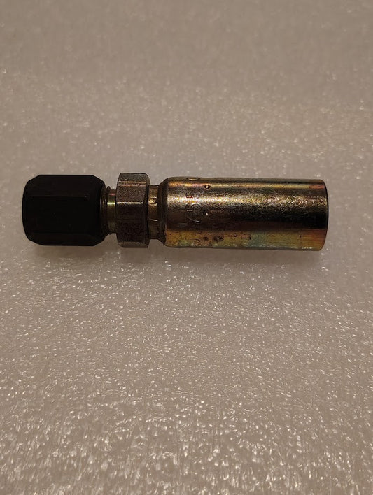 A Weatherhead 04U-755 1/4 hose x 5/16 compression fitting (CS28-4X5) with a hexagonal black cap rests on a textured white surface. The metal fitting is cylindrical and has a shiny, slightly tarnished look.