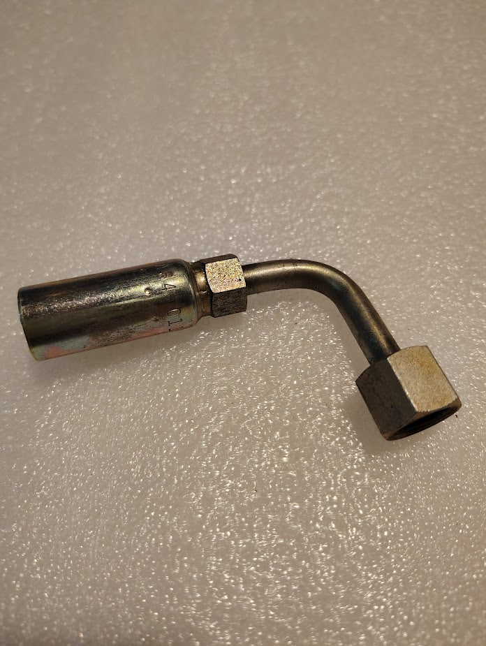 A 04U-A64 Weatherhead fitting with a 1/4 hose and 1/4 ORF female swivel ends lies on a textured, light surface. Its reflective finish and angled bend make it perfect for hydraulic hose systems.