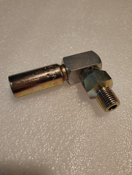 A Weatherhead 04U-M04 1/4 Hose x 1/4 NPTF Male Fitting (CS14-4X4) with a 90-degree elbow and filter/silencer rests on a textured surface.