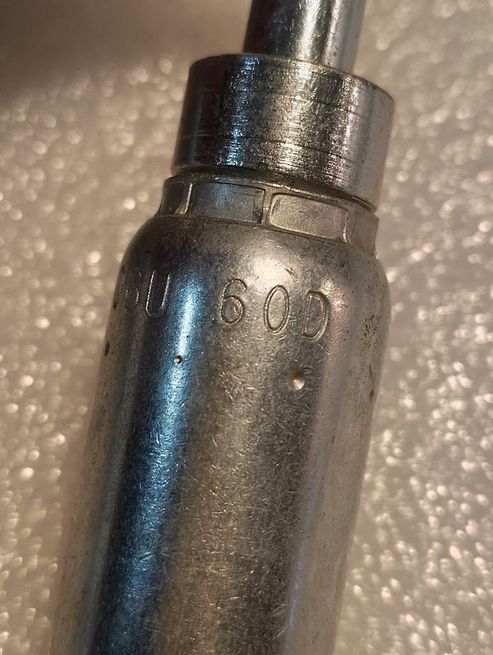 A close-up of the 06U-60D | Weatherhead 3/8 Hose x M16x1.5 DIN Female Fitting (CS44-6X10) shows its metallic cylindrical shape with 60D engraved, set against a textured white background—typical for hydraulic hose fittings.