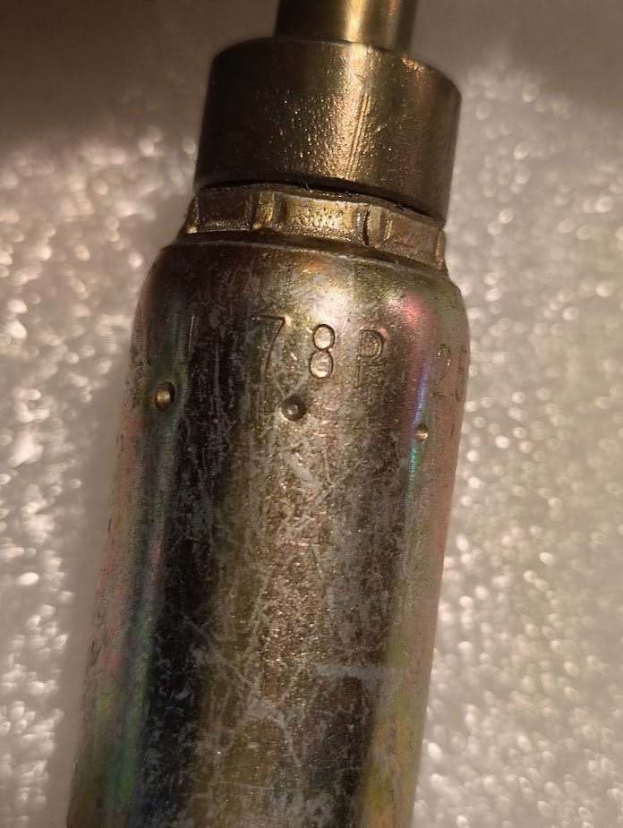 Close-up of a metallic Weatherhead 06U-78P fitting (3/8 hose x 1/2 BSPP female, CS46-6X8) with engraved markings 178R and other codes. The worn, discolored metal surface contrasts with a textured white background.