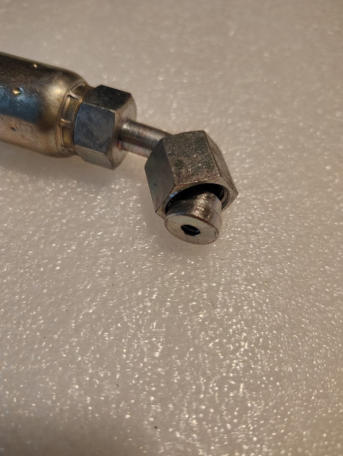 Close-up of a Weatherhead 06U-A24 CS32-6X4 3/8 Hose x 1/4 ORF Female Fitting, featuring a hexagonal nut and cylindrical end, shown on a textured white surface. Compatible with 100R1 hydraulic hose fittings.