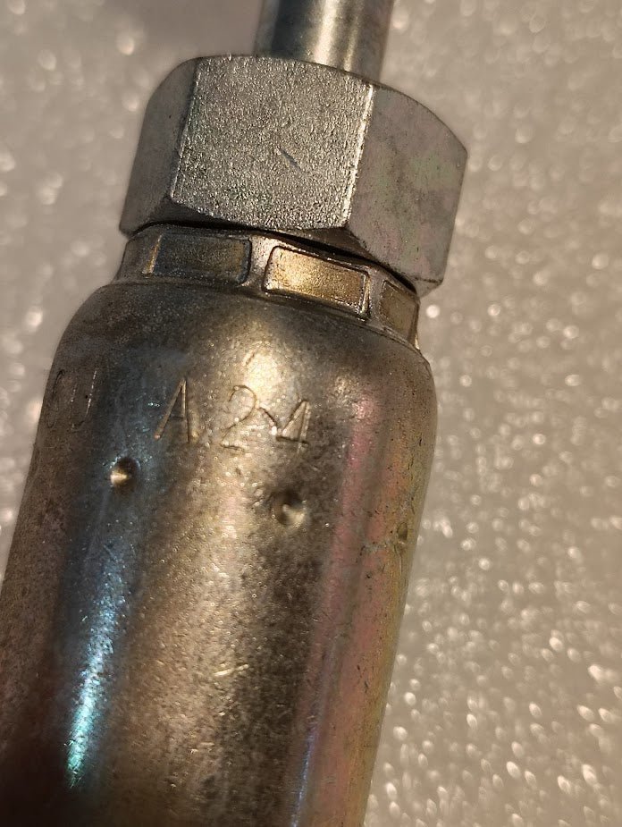 A close-up of the Weatherhead 06U-A24, a 3/8 hose x 1/4 ORF female fitting (CS32-6X4), shows the engraved “A24” on the hex nut against a textured background—ideal for highlighting 100R1 compatible hydraulic hose fittings.