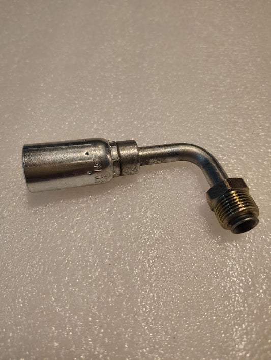 The 06U-B67 Weatherhead 3/8 hose x 7/16 inverted male fitting (CS20-6X7), a metal pipe with a 90-degree bend and threaded brass end, is displayed on a textured white surface.