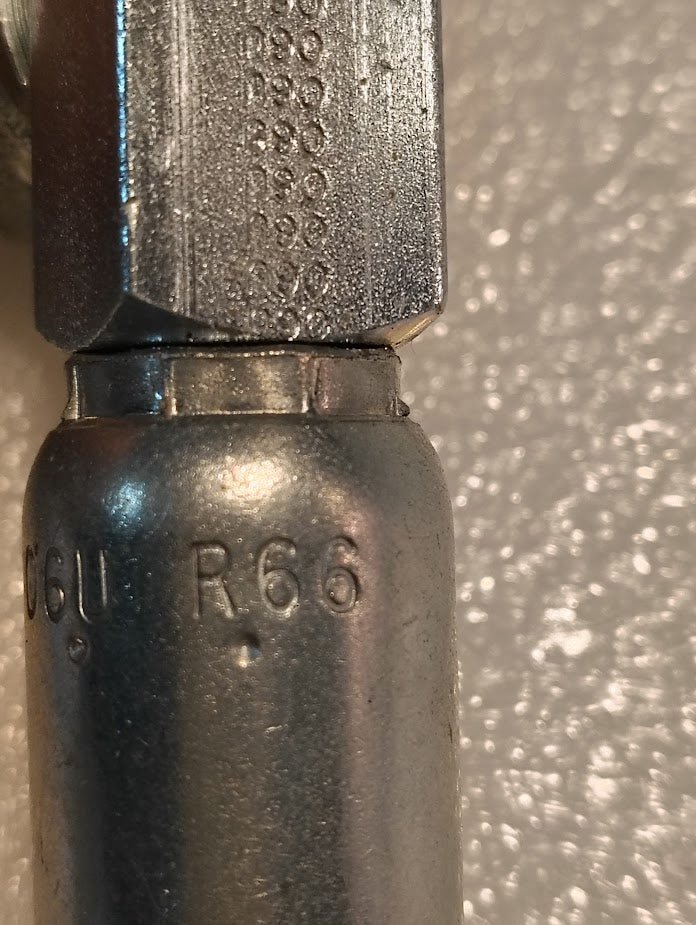 Close-up of a 06U-R66 Weatherhead 3/8 Hose x 3/8 ORB Male Fitting (CS15-6X6), featuring engraved R66 and C6U markings, commonly used with hydraulic hoses, shown against a light textured background.
