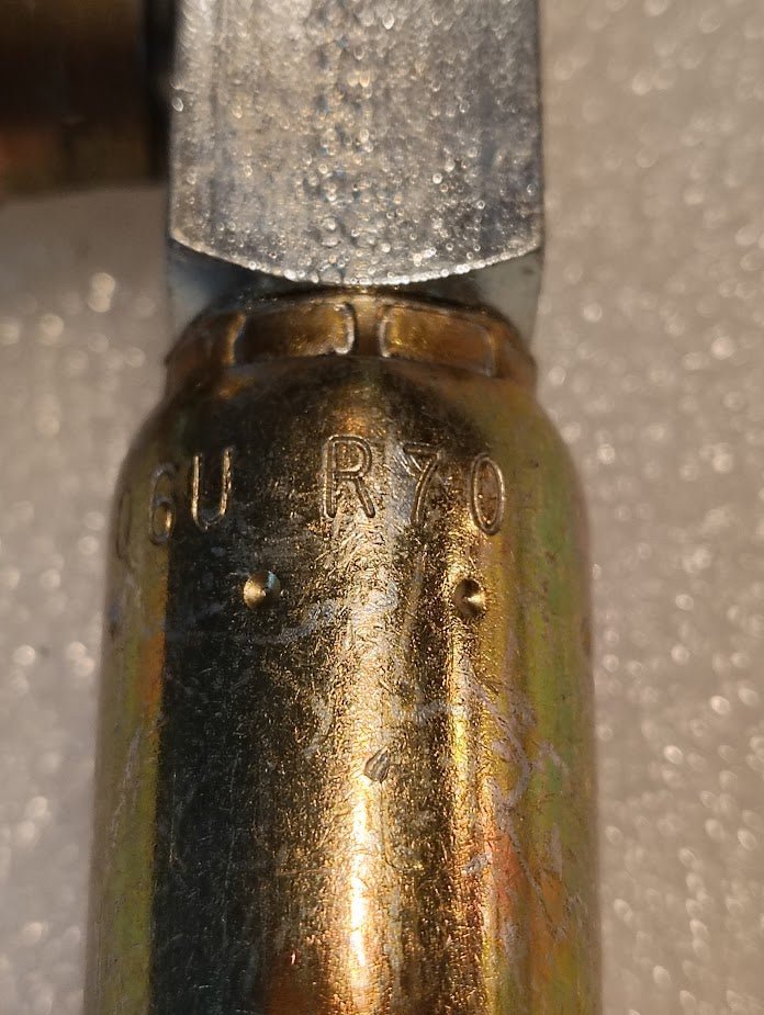 Close-up of a 06U-R70 Weatherhead 3/8 Hose x 5/8 ORB Male Fitting (CS15-6X10) with “16U R70” markings and two indentations, set against a textured white background.