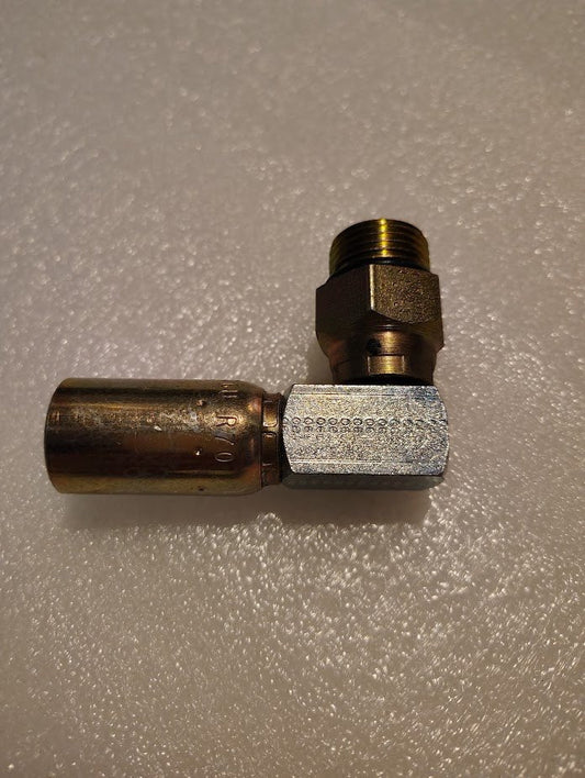 A close-up of a Weatherhead 06U-R70 3/8 Hose x 5/8 ORB Male Fitting (CS15-6X10) with a brass finish, similar to Parker fittings, showing its right-angle design and threaded ends on a textured white surface.