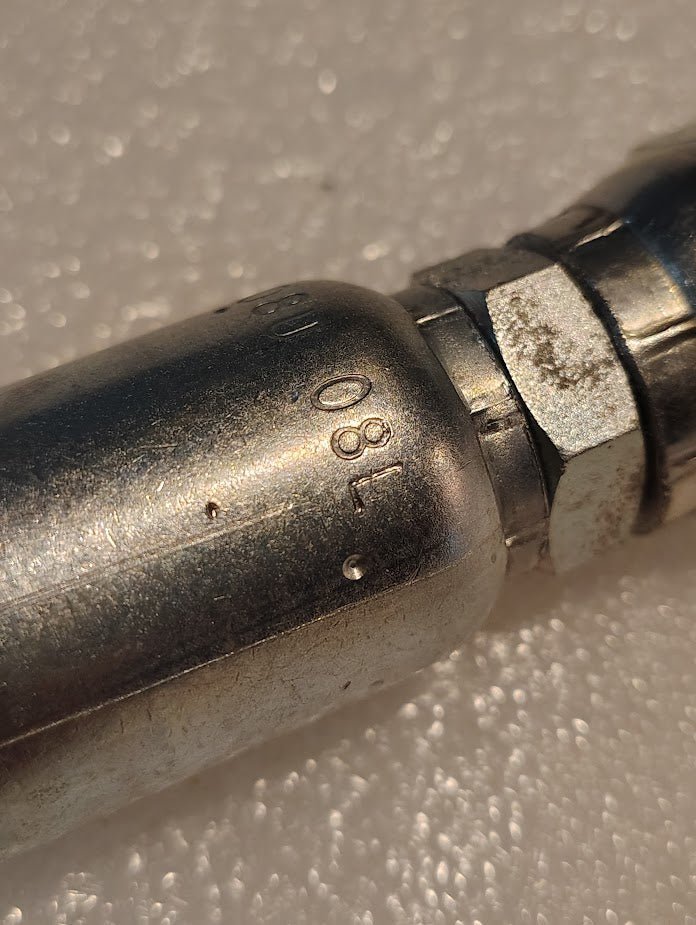 A close-up of the Weatherhead 08U-08L CS40-8X8, a 1/2 hose x 1/2 JIS female fitting, shows metallic construction with engraved numbers 180, set against a textured white background.