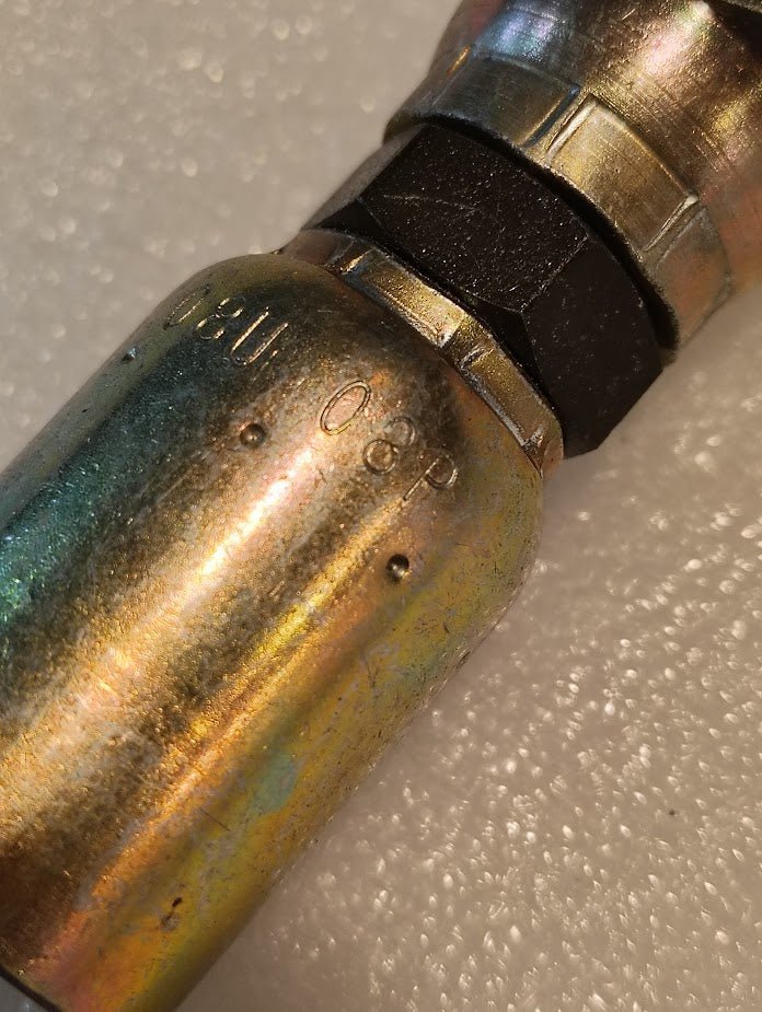 Close-up of a metal 08U-08P Weatherhead 1/2 Hose x 1/2 BSPP Swivel Fitting—straight type with 06P marking—shown on a textured white background, compatible with BSPP female swivel connections.