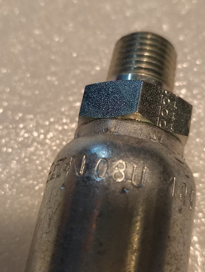 Close-up of a Weatherhead 08U-104 (1/2 Hose x 1/4 NPTF Male Fitting, CS01-8X4) metallic threaded valve with engraved codes, typically used with hydraulic hose fittings, on a textured white background.