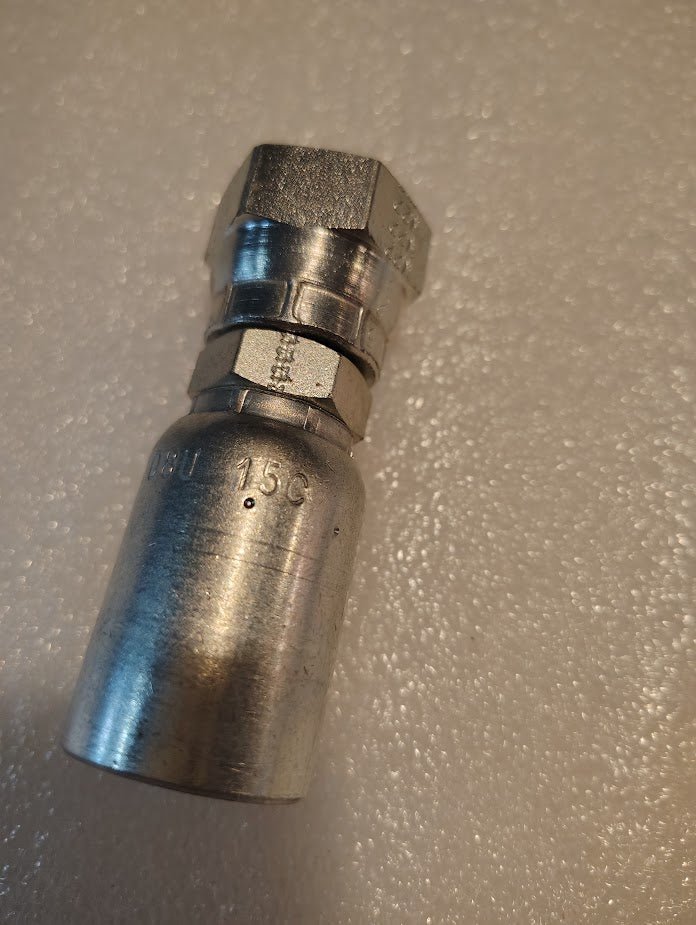 A close-up of the Weatherhead 08U-15C, a 1/2 hose x M22x1.5 DIN female fitting (CS37-8X15), for 100R series hoses. It features a hexagonal nut and engravings, resting unused on a textured white surface.