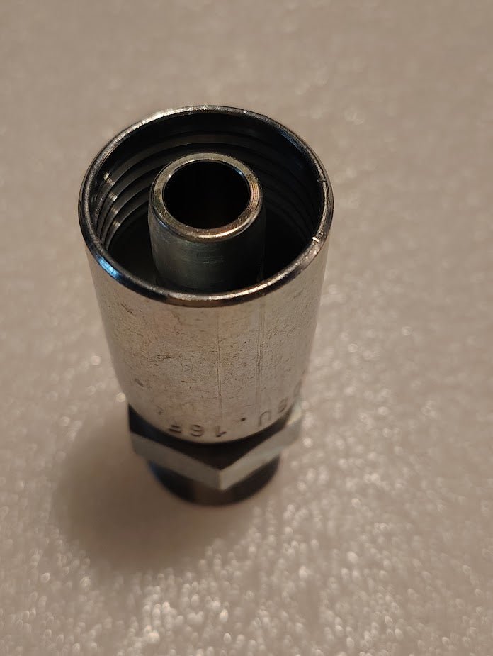 Close-up of the Weatherhead 08U-16F (1/2 Hose x M24x1.5 DIN Male Fitting, CS67-8X16) metal connector with a threaded interior, shown on a white textured surface—perfect for compatible hoses and hydraulic applications.