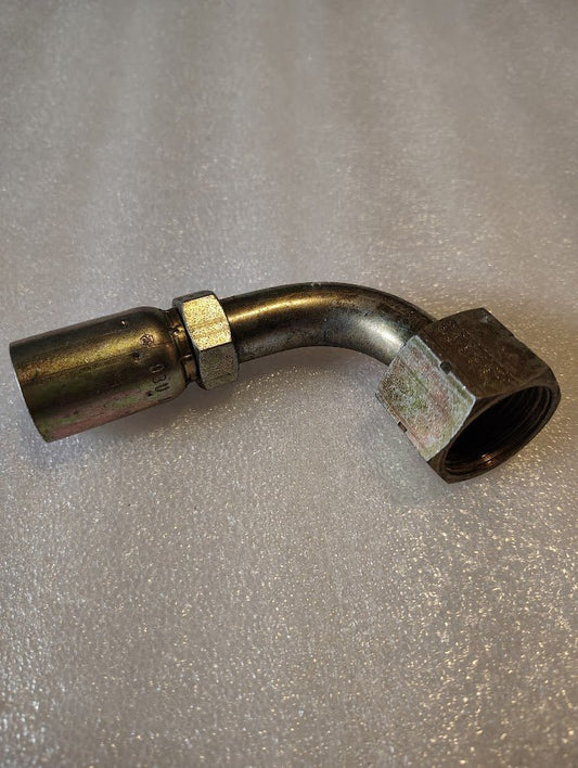 The 08U-A32 Weatherhead 1/2 Hose x 3/4 ORF Female Fitting (CS32-8X12), a metal hydraulic fitting with a 90-degree bend, is shown on a textured, light surface. It’s made for use with 100R1 hoses and features a threaded hex nut.