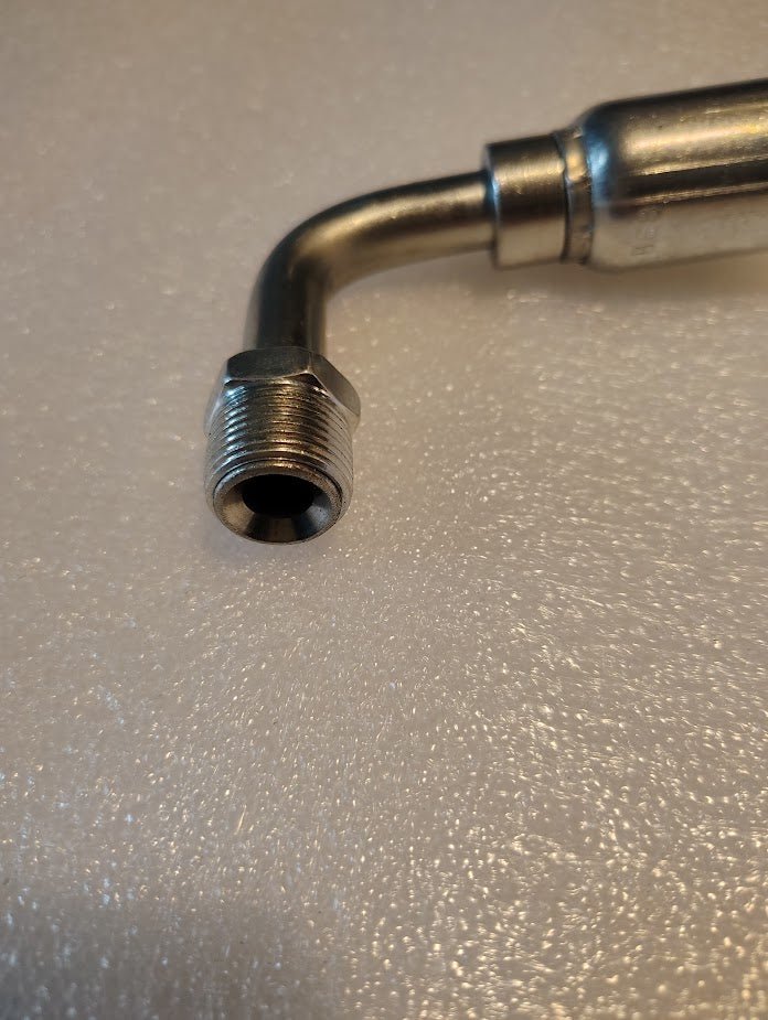 Close-up of the 08U-B68 Weatherhead 1/2 Hose x 1/2 Inverted Male Fitting (CS20-8X8), showing its threaded, right-angle metal design on a textured white surface—compatible with Weatherhead hoses and fittings.