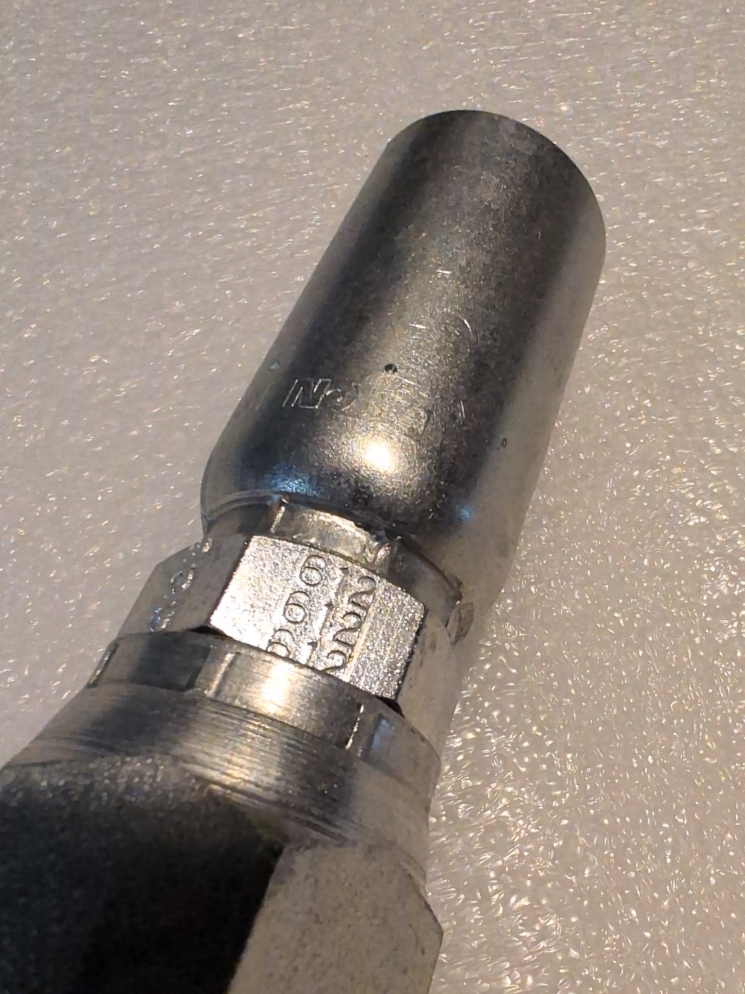 Close-up of a Weatherhead 10U-612 (CS09-10X12) 5/8 hose x 3/4 JIC female fitting with hexagonal nut on a textured white surface, suitable for hydraulic hose fittings and pneumatic connections.