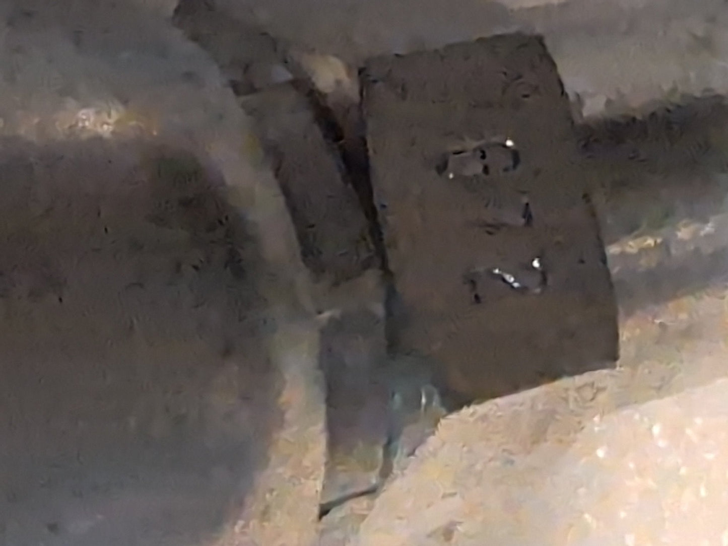 A close-up of the 10U-672 Weatherhead 5/8 Hose x 3/4 JIC Female Fitting (CS26-10X12), showing its hexagonal metallic form with engraved R and N, set in an industrial, gray-toned environment suggestive of hydraulic hose fittings.