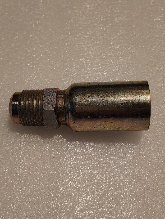 A 12U-312 Weatherhead fitting, resembling other Weatherhead models, is on a textured white surface. It is a brass pipe fitting with threads, a cylindrical shape, and a hexagonal section near the thread for easy interchangeability with hydraulic hose components.