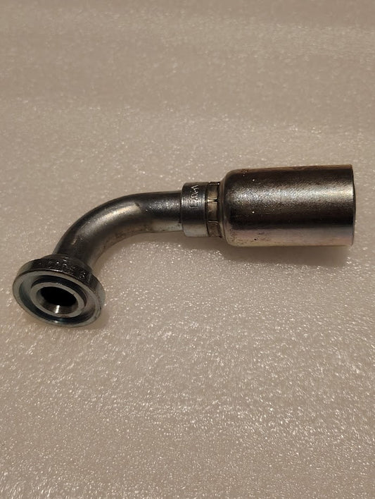 A Weatherhead 12U-G72 hydraulic fitting, 3/4 hose x 3/4 Code 61 flange (CS53-12X12), has a metal 90-degree bend with a wide flange on one end and a cylindrical connector on the other, placed on a textured, light surface. Compatible with 100R1.