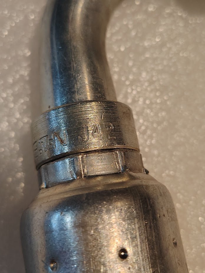 Close-up of a Weatherhead 12U-J42 3/4 Hose x 3/4 ORF Female Fitting (CS34-12X12) with engraved “JN J42” marking, commonly used for hydraulic hoses, set against a textured white background.