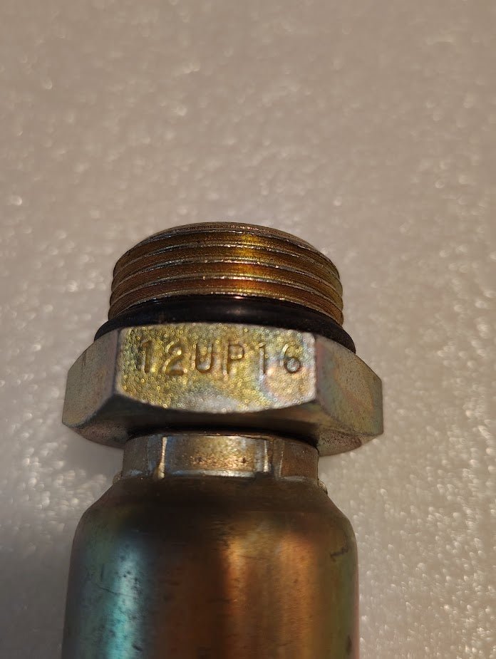 Close-up of the Weatherhead 12U-P16 (CS11-12X16) 3/4 hose x 3/8 ORB male fitting with a hexagonal nut, engraved with 12UP13—perfect for compatible hydraulic hose or Weatherhead fitting applications.