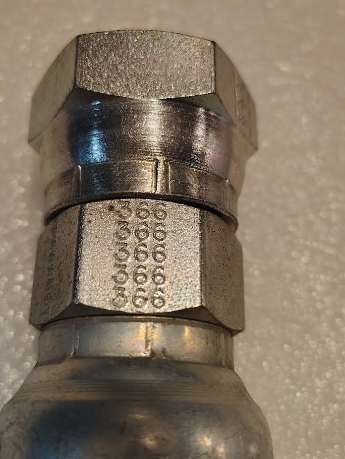 Close-up of a 16U-366 | Weatherhead 1 Hose x 1 BSPP Female Fitting (CS10-16X16), a metal hexagonal fitting with engraved numbers and letters, resting on a white textured background.