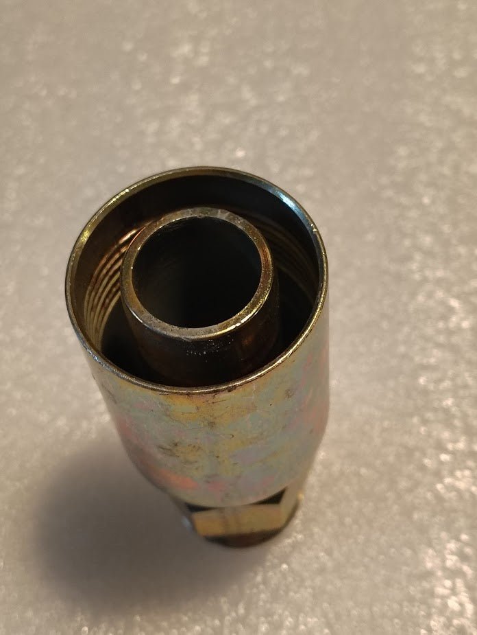 A close-up of the Weatherhead 16U-514, a 1 hose x 7/8 SAE male fitting (CS08-16X14) with inner threading, designed for hydraulic systems, shown on a textured light surface.