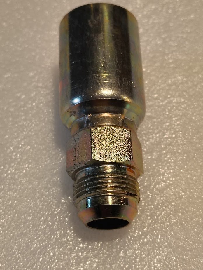 A close-up photo of the 16U-514 Weatherhead 1 Hose x 7/8 SAE Male Fitting (CS08-16X14) with a hexagonal nut and threaded end on a textured white surface, perfect for highlighting compatible Weatherhead fittings.
