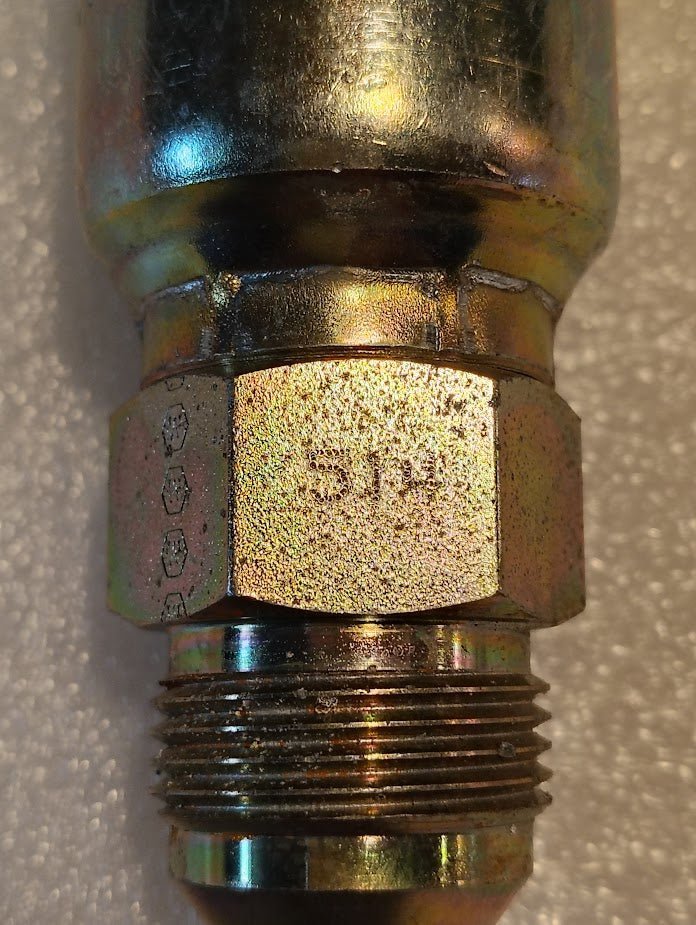 A close-up of the Weatherhead 16U-514, a 1 hose x 7/8 SAE male fitting (CS08-16X14), shows its threaded metal hex nut and S18 marking, with an iridescent finish resting on a textured light surface for hydraulic hoses.