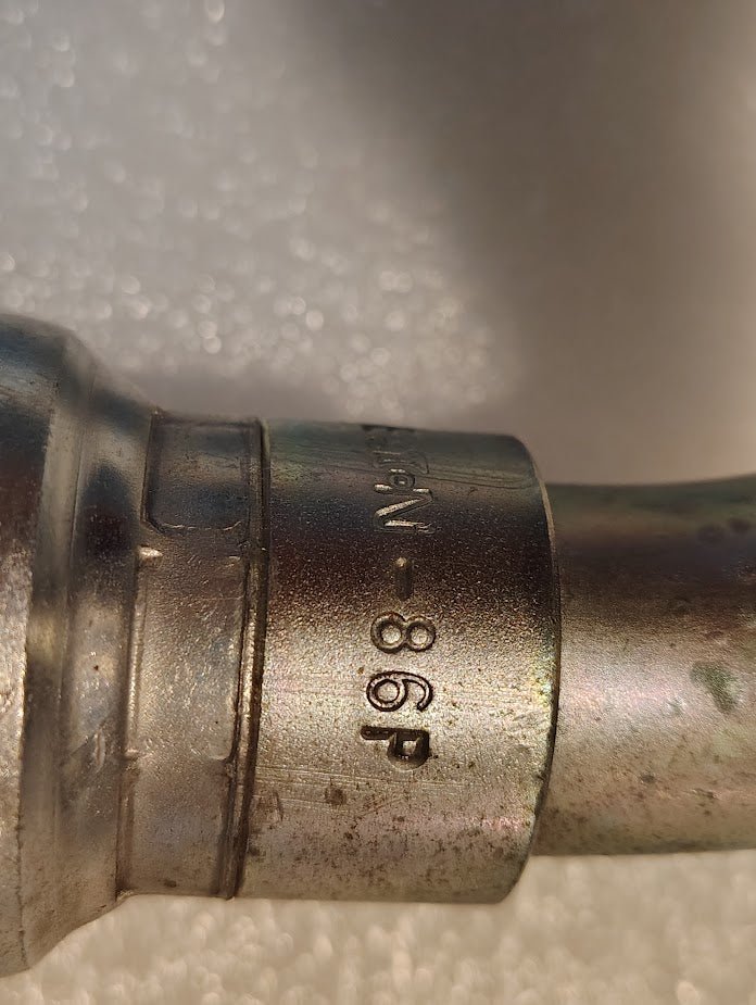Close-up of a Weatherhead 16U-86P 1 Hose x 1 BSPP Female Fitting (CS46-16X16) with engraved “198-86P” and partial numbers on its slightly worn metallic surface, set against a white textured background.