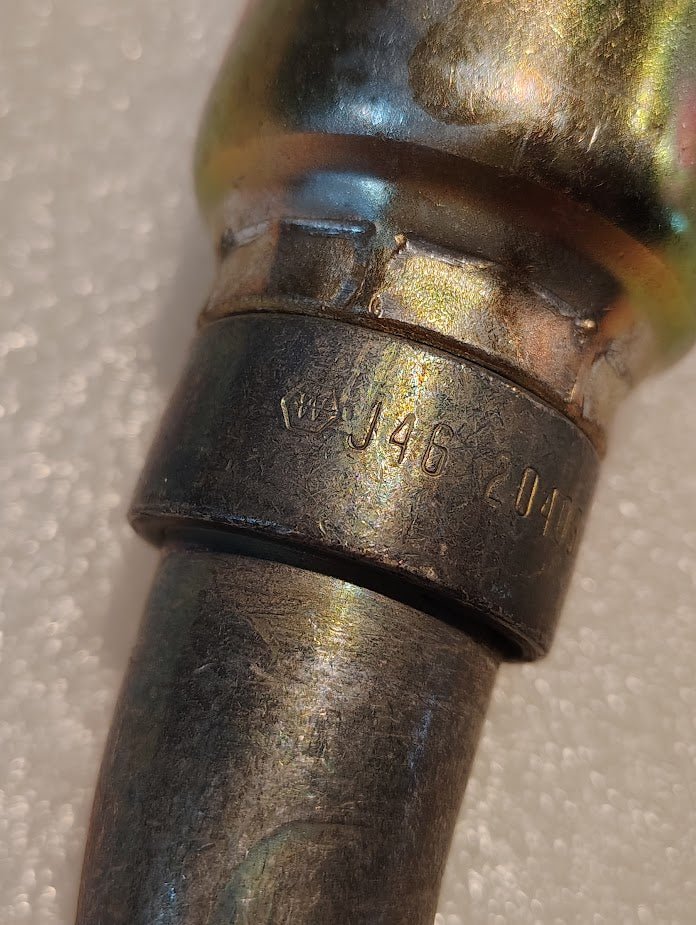 A close-up of a Weatherhead 16U-J46 fitting (1 Hose x 1 ORF Female, CS34-16X16) with J46 204 engraved on its slightly tarnished metallic surface, shown against a textured white background.