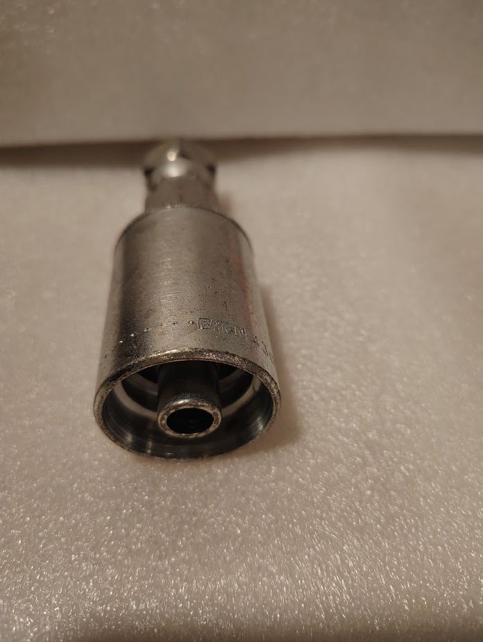 A close-up of the Weatherhead 43008U-608, a 1/2 Hose x 1/2 JIC Female Fitting (GW09-8x8), shows its metal cylinder design on a soft white textured surface, with one hollow end facing the camera and the other blurred.