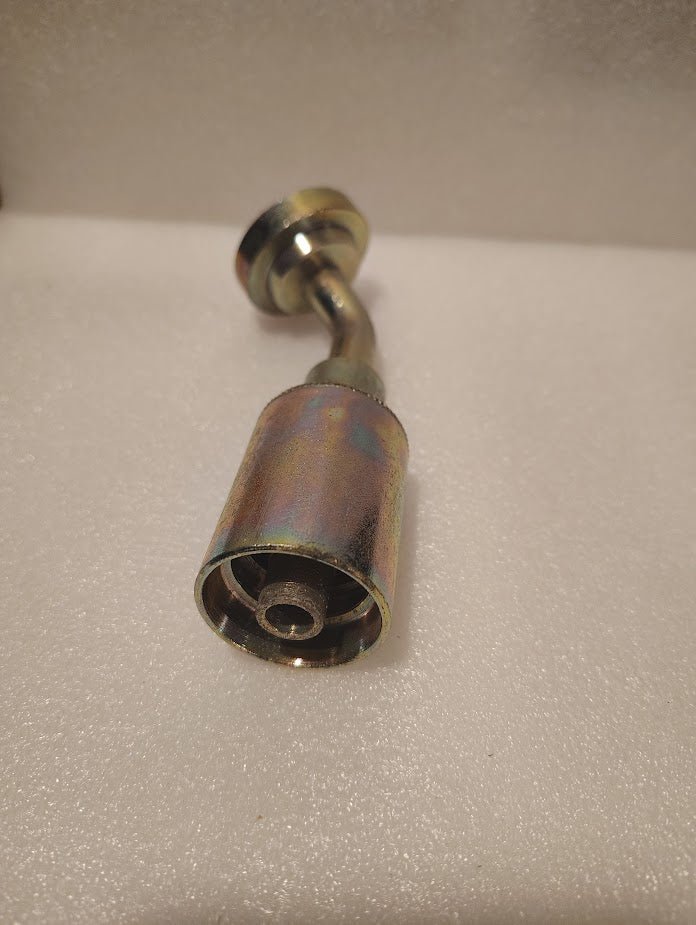 A close-up of the 43008U-D42 | 1/2 Hose x 3/4 Code 62 Flange Fitting with a 45-degree bend (GW61-08x12), a metallic, cylindrical pipe fitting, placed on a textured white surface.