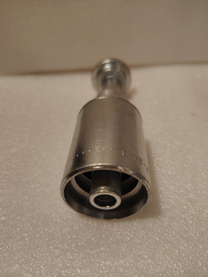 A close-up of the 43008U-G08 Weatherhead 1/2 Hose x 1/2 Code 61 Flange Fitting (GW47-8x8) shows its threaded, cylindrical design—perfect for hydraulic hose connections on light-colored, textured surfaces.