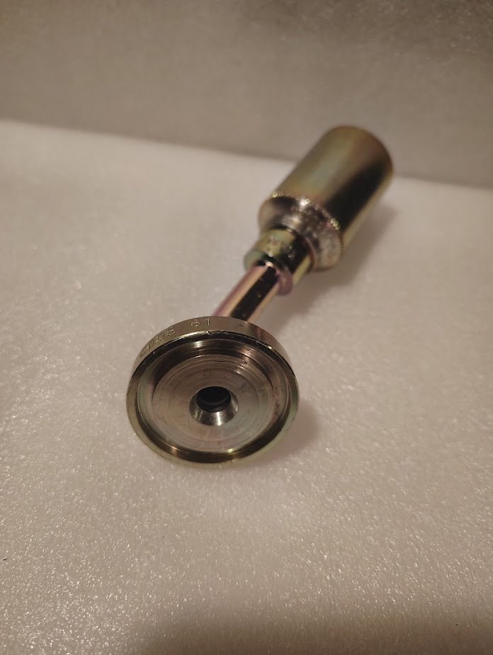 A close-up photo of the 43008U-G46 | 1/2 Hose x 1 Code 61 Flange Fitting - 45 bend (GW50-8x16), featuring its round, flat end and cylindrical handle, resting on a white textured surface.