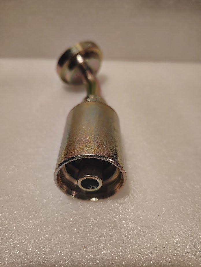 Close-up of a 43008U-G46 | 1/2 Hose x 1 Code 61 Flange Fitting - 45 bend (GW50-8x16) on a white textured surface, with the nozzle opening and internal components in sharp focus.