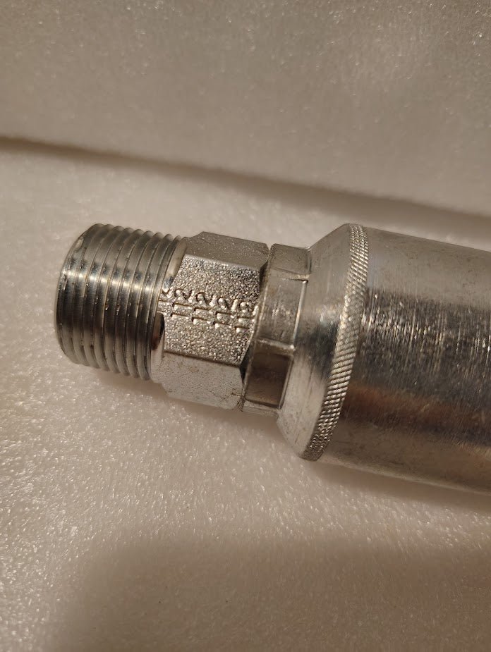 Close-up of a Weatherhead 43012U-112 (GW01-12x12) 3/4 hose x 3/4 NPTF male metallic pipe fitting with knurled hex nut, shown on a white textured surface.