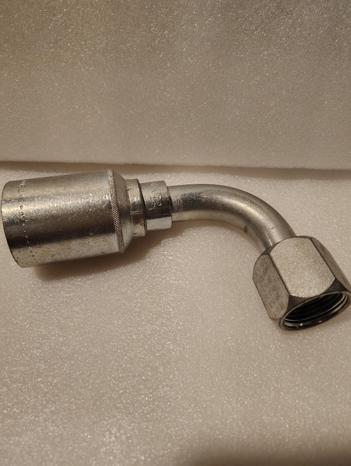 A Weatherhead 43012U-672 3/4 hose x 3/4 JIC female fitting (GW26-12x12), featuring a metallic body with a 90-degree bend and hex nut end, is shown on a textured white surface.