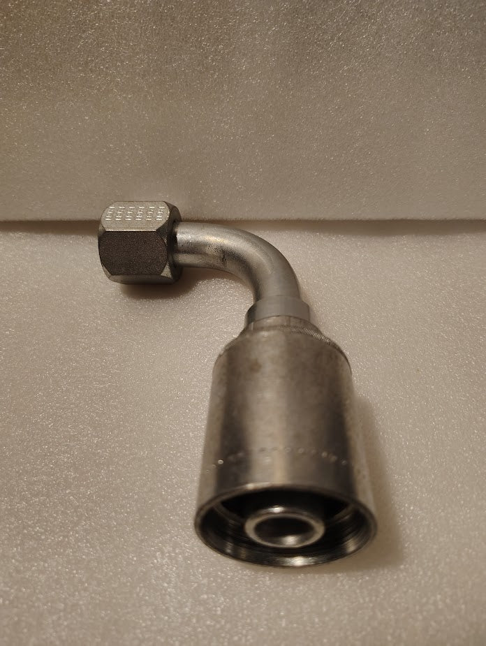 A Weatherhead 43012U-672 (GW26-12x12) fitting, with a 90° bend, hex nut, and cylindrical connector, fits 3/4 hoses to 3/4 JIC female ends and ensures compatibility—displayed on a textured surface.