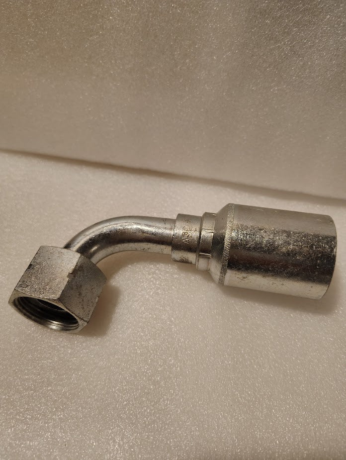 A close-up of the Weatherhead 43012U-A32, a 3/4 Hose x 3/4 ORFS Female Fitting (GW32-12x12), showing its 90-degree bend, hexagonal nut, and cylindrical connector on a light textured background. Couplamatic compatible.