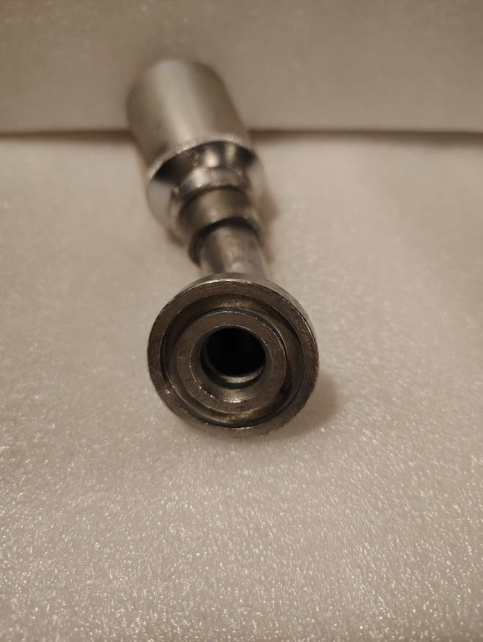 A close-up of a metal socket wrench attachment on a soft, white surface, perfect for installing the Weatherhead 43012U-G42 3/4 Hose x 3/4 Code 61 Flange Fitting (GW50-12x12) or other compatible hydraulic hose fittings.