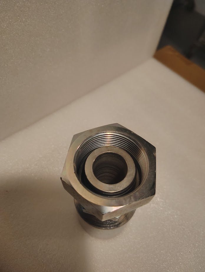 A close-up of a 43016U-80C | 1 Hose x M42x2.0 DIN Heavy (Metric S) Swivel Fitting - Straight (GW38-16x30), showing its metallic hexagonal body, threads, and inner sections on a white surface.