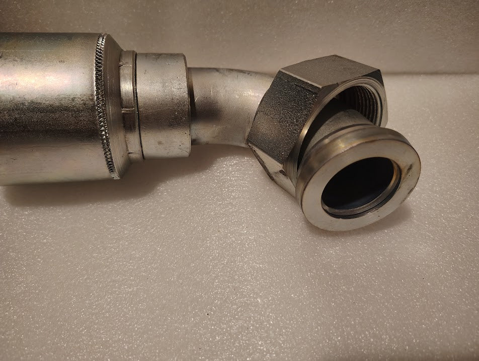 A close-up of the 43024U-A44, a 1 1/2 hose x 1 1/2 ORFS swivel fitting with a short 90° bend, shown on a textured white surface—perfect for hydraulic applications needing the GW32-24x24 connector.