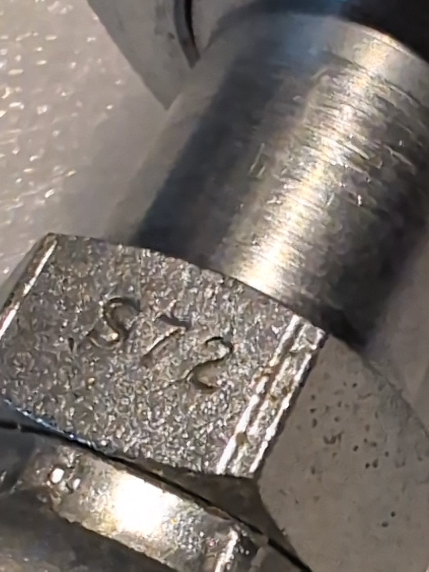 The close-up displays a metallic nut engraved with S72, threaded onto a shiny cylindrical bolt, resembling the Weatherhead 10U-S72 5/8 Hose x 3/4 ORF Female Fitting. Its textured sheen and wear indicate its vital for secure connections in diverse applications.
