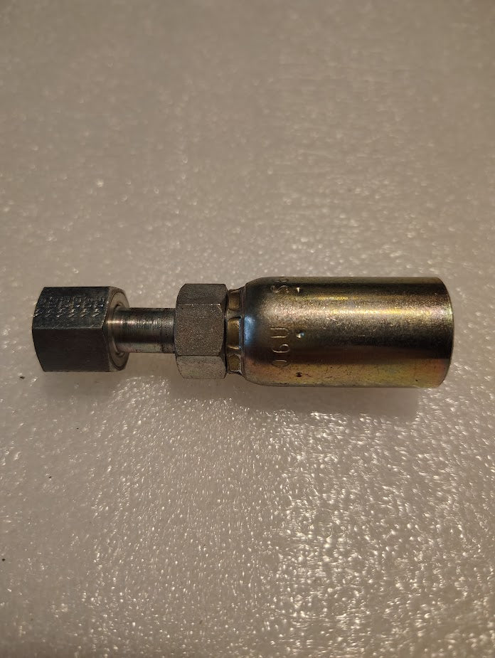 A 06U-S64 Weatherhead 3/8 Hose x 1/4 ORF Female Fitting, featuring a threaded hexagonal end and cylindrical connector, lies on a textured white surface. Tapered towards one end, it appears polished and clean.